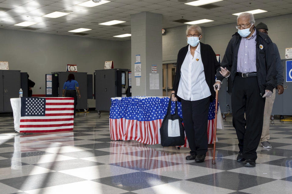 A couple leaves the polls after voting on the first day of early voting in Atlanta on Monday, Oct. 17, 2022. (AP Photo/Ben Gray)