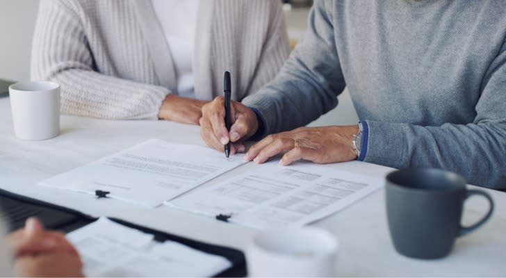 A couple signs a batch of estate planning documents in front of their estate planning attorney. 