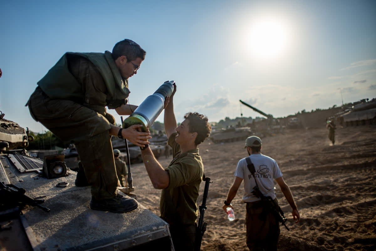  Israeli forces prepare at an undisclosed location along the border with Gaza in southern Israel on Saturday  (EPA)