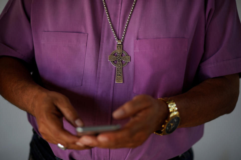 Bishop David Alvarado, of the Anglican Episcolpal Church in El Salvador, checks messages on his cellphone after an interview with Reuters in La Libertad, El Salvador, on Jan. 11, 2020.&nbsp; (Photo: Jose Cabezas / Reuters)