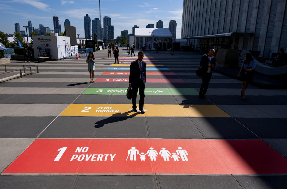 People walk along a plaza at United Nations Headquarters Saturday, Sept. 21, 2019. (AP Photo/Craig Ruttle)