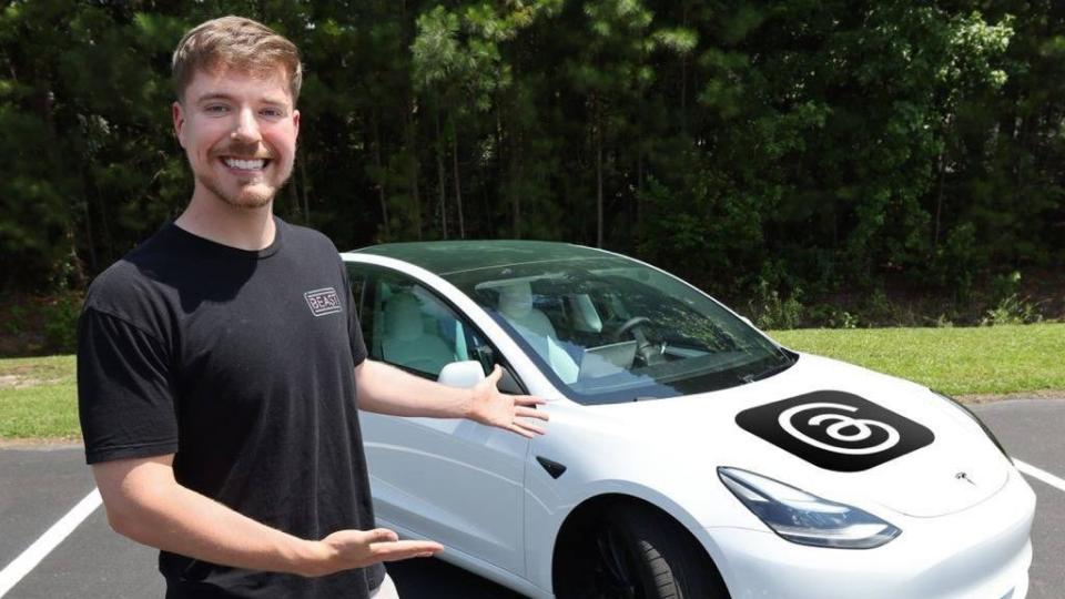 Mr beats stood next to a white car with the Threads logo on the hood.