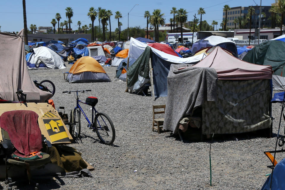 FILE - A large homeless encampment sits in Phoenix, on Aug. 5, 2020. The city is wrangling with two dueling lawsuits as it tries to manage a homelessness crisis that has converted its downtown into a tent city housing hundreds of people under the blazing desert sun just as summer temperatures soar into the 90s. (AP Photo/Ross D. Franklin, File)