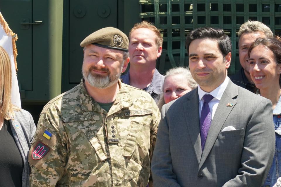 London North Centre MP MP Peter Fragiskatos and Ukrainian Colonel Andrii Shmilyk stand side by side, flanked by General Dynamics employees at Wednesday's event.