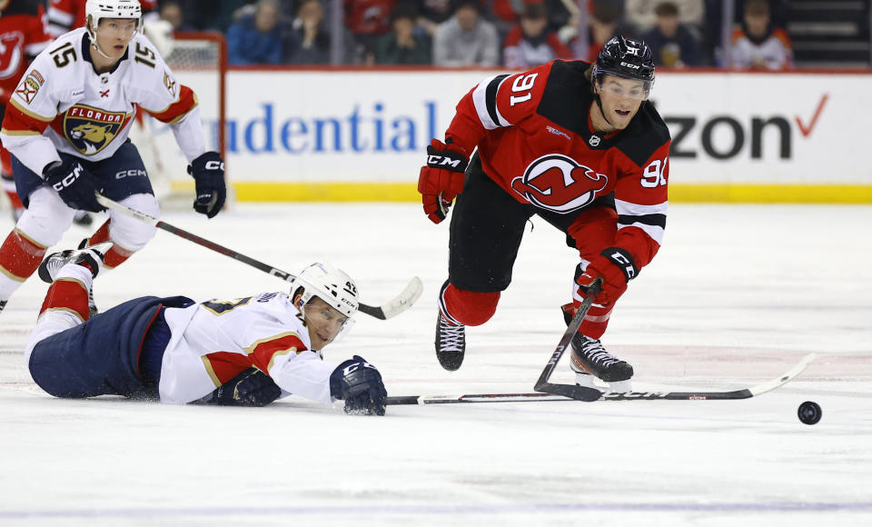 Florida Panthers defenseman Gustav Forsling (42) passes the puck against New Jersey Devils center Dawson Mercer (91) during the second period of an NHL hockey game, Tuesday, March 5, 2024, in Newark, N.J. (AP Photo/Noah K. Murray)