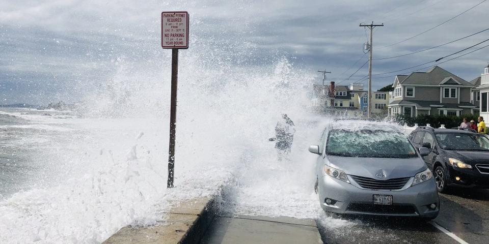 A beachgoer is drenched by a wave crashing against the seawall in Kennebunk, Maine, on Saturday, Sept. 16, 2023.