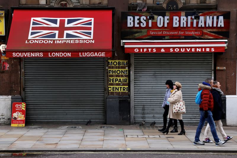 People walk in pairs past closed shops