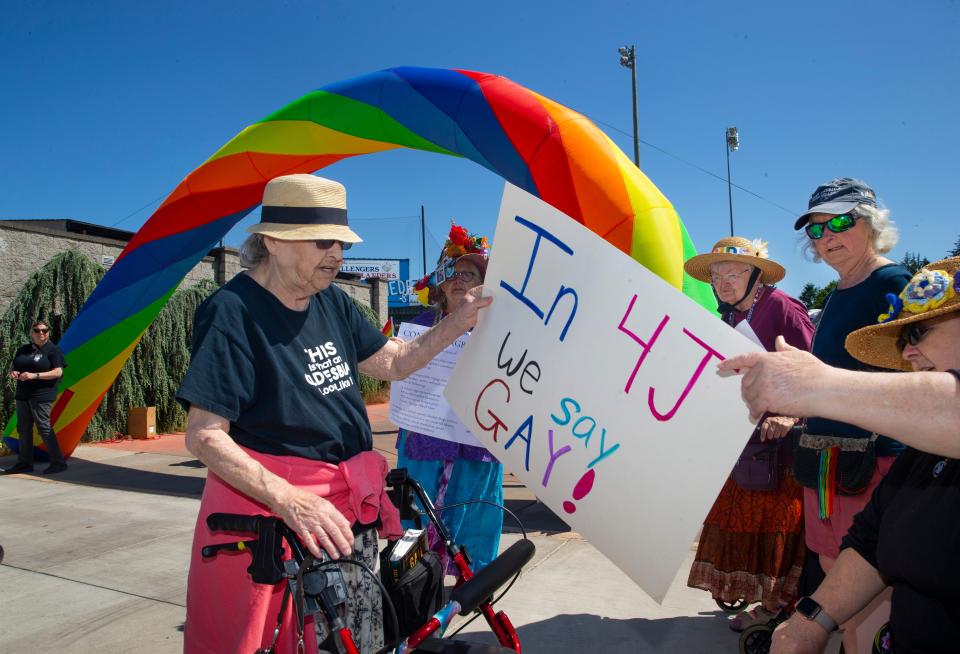 Raging Granny D. Maria, left, selects a sign made by students as she joins fellow Grannies outside the 4J Pride Festival at North Eugene High School.