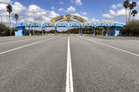FILE - This March 24, 2020, file photo shows the parking plaza entrance to the Magic Kingdom as Walt Disney World enters its second week of being shut down in response to the coronavirus pandemic. Despite a huge surge of Floridians testing positive for the new coronavirus in recent weeks, Magic Kingdom and Animal Kingdom, two of Disney World's four parks are reopening Saturday, July 11. (Joe Burbank/Orlando Sentinel via AP, File)