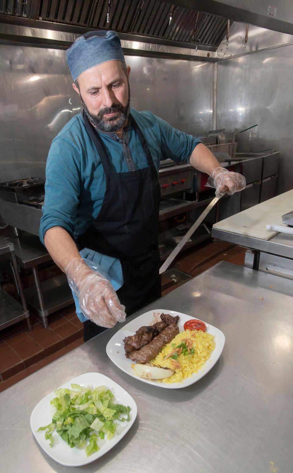 Chef Mohsen Alaruri creates his signature Middle Eastern menu items at the new Beyt Lahm restaurant on West Fairfield Drive on Friday.