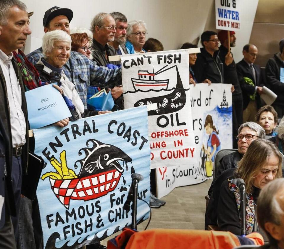Supporters of the Chumash Heritage National Marine Sanctuary holds signs during the Board of Supervisors meeting Feb. 7, 2017.