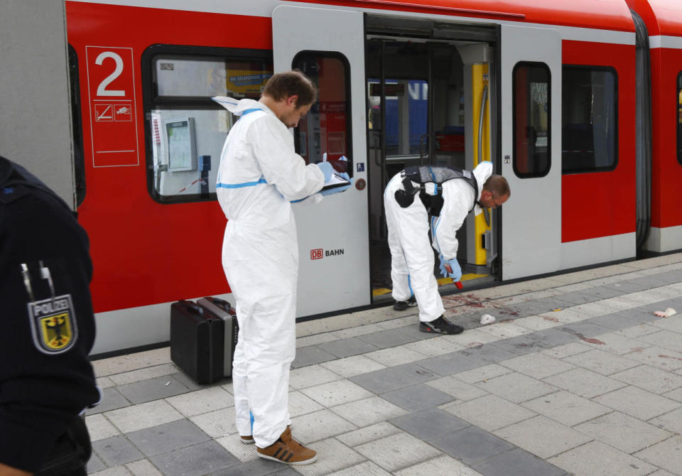 Police investigate the scene of a stabbing at a station in Grafing near Munich, Germany, Tuesday, May 10, 2016. (AP Photo/Matthias Schrader)