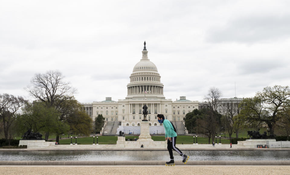 UNITED STATES - APRIL 4: A man wearing a bandana as a face mask roller blades past the U.S. Capitol building in Washington on Saturday, April 4, 2020. (Photo By Bill Clark/CQ-Roll Call, Inc via Getty Images)