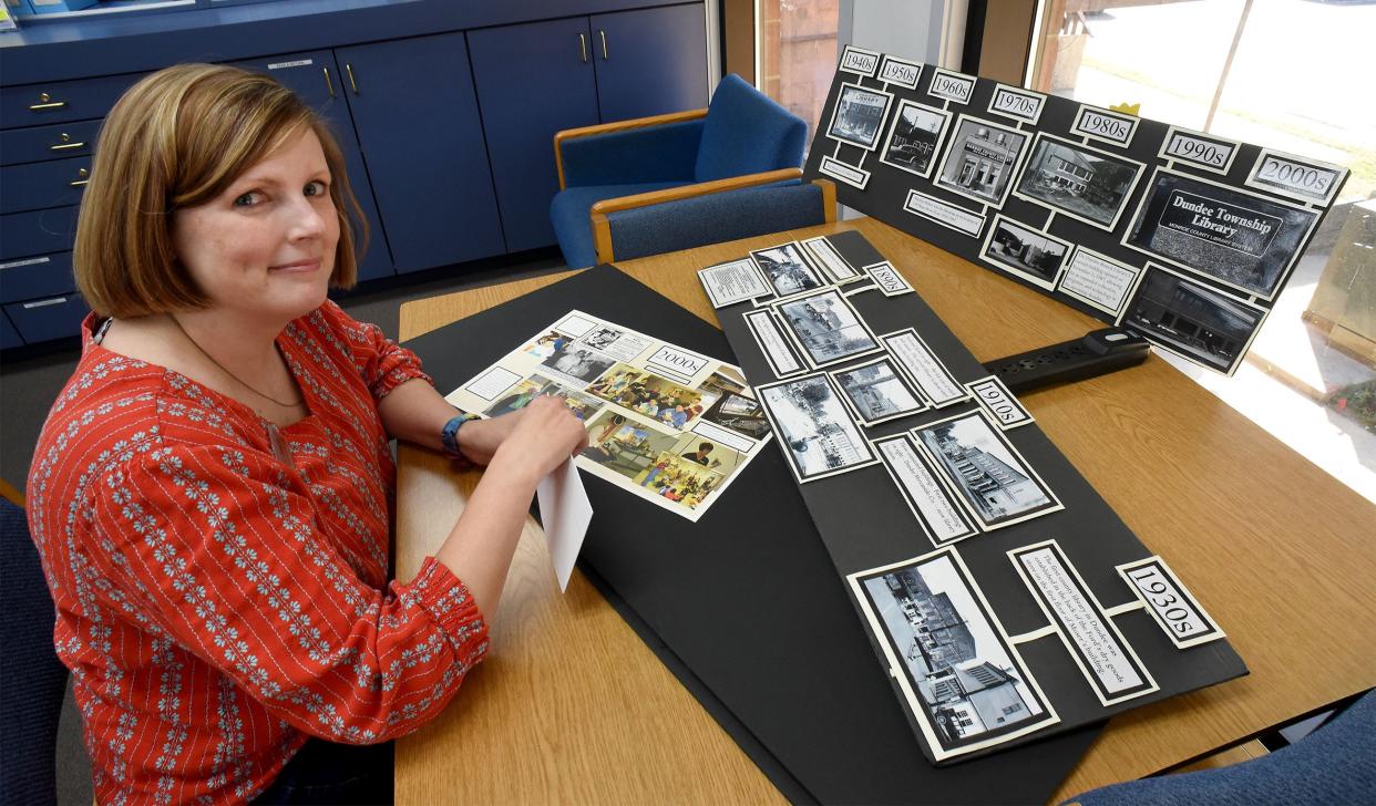 Community Librarian Jennifer Grudnoski at the Dundee Branch Library puts together a history board about the library before Monday's 90th anniversary celebration for the Monroe County Library System.