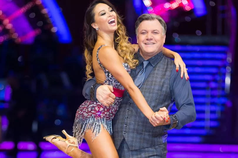 Katya Jones in a short sparkly dress being lifted by partner Ed Balls at Strictly photoshoot 19 Jan 2017