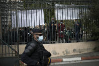 Restaurant owners look through the gates of La Timone public hospital during a demonstration while French Health Minister Olivier Veran visits in Marseille, southern France, Friday Sept. 25, 2020. Angry restaurant and bar owners demonstrated in Marseille to challenge a French government order to close all public venues as of Saturday to battle resurgent virus infections. The government argues that hospitals in this Mediterranean city are under strain and the closures are the only way to stem the spread while avoiding new lockdowns. (AP Photo/Daniel Cole)