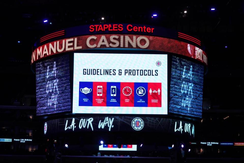 Health and hygiene protocols are displayed on the Staples Center during an NBA game between the LA Clippers and the Lakers earlier this year.