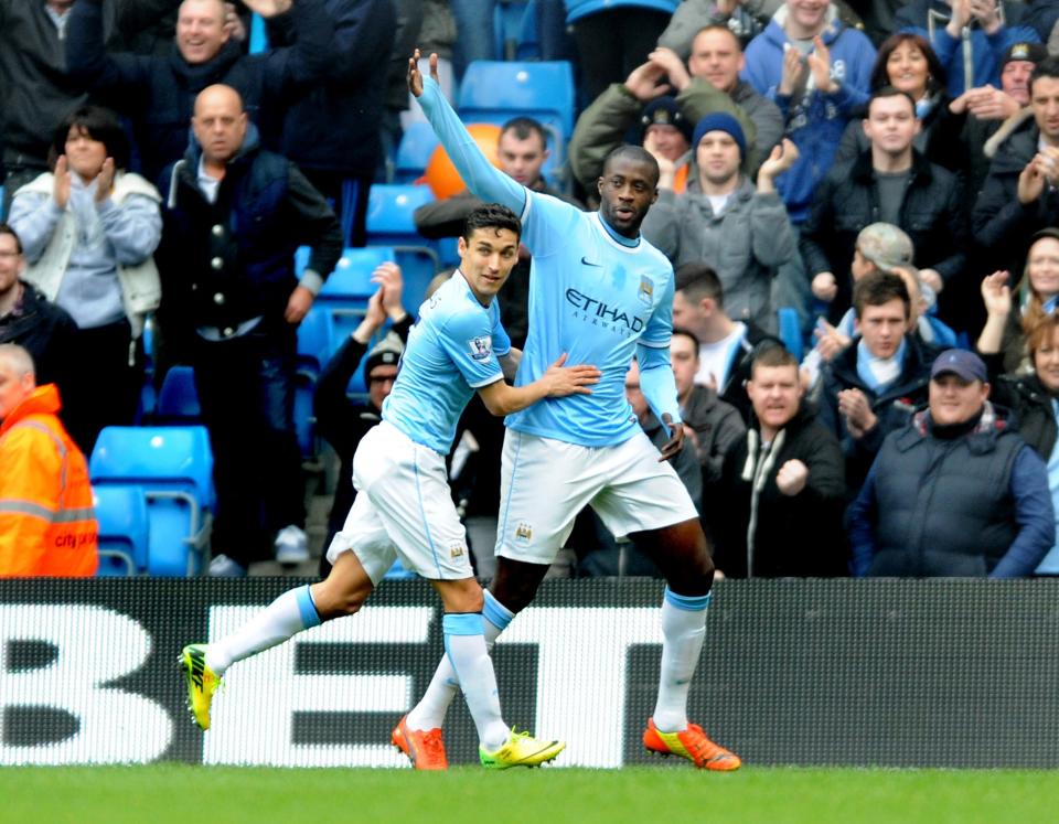 Manchester City's Yaya Toure, right, celebrates with teammate Jesus Navas after scoring from the penalty spot against Southampton during the English Premier League soccer match between Manchester City and Southampton at The Etihad Stadium, Manchester, England, Saturday, April 5, 2014. (AP Photo/Rui Vieira)