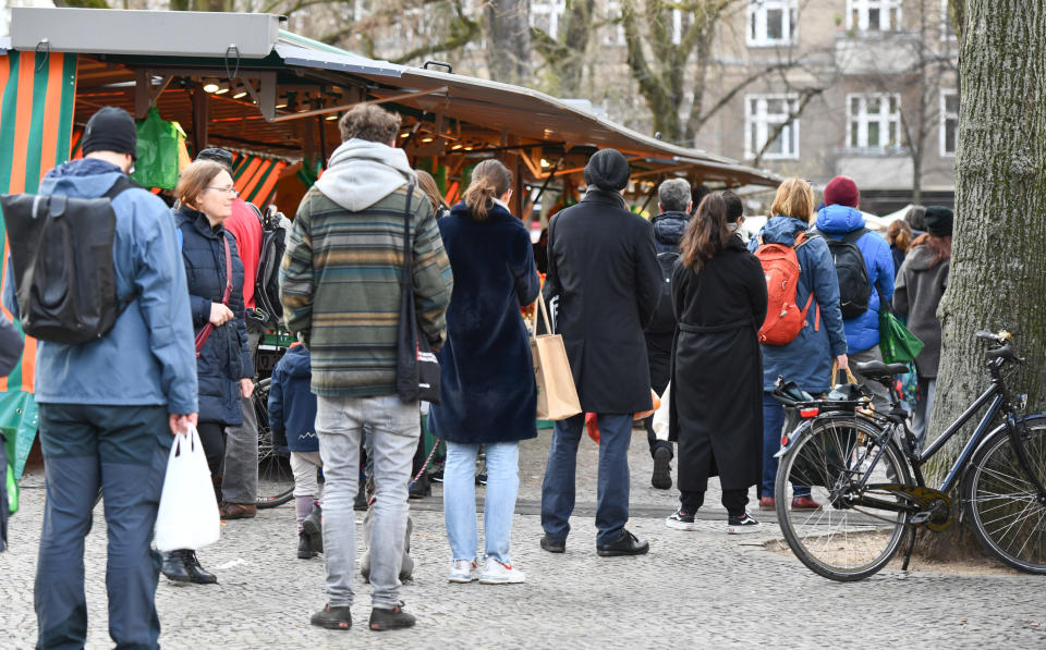 People wait in a queue at the weekly market in Berlin