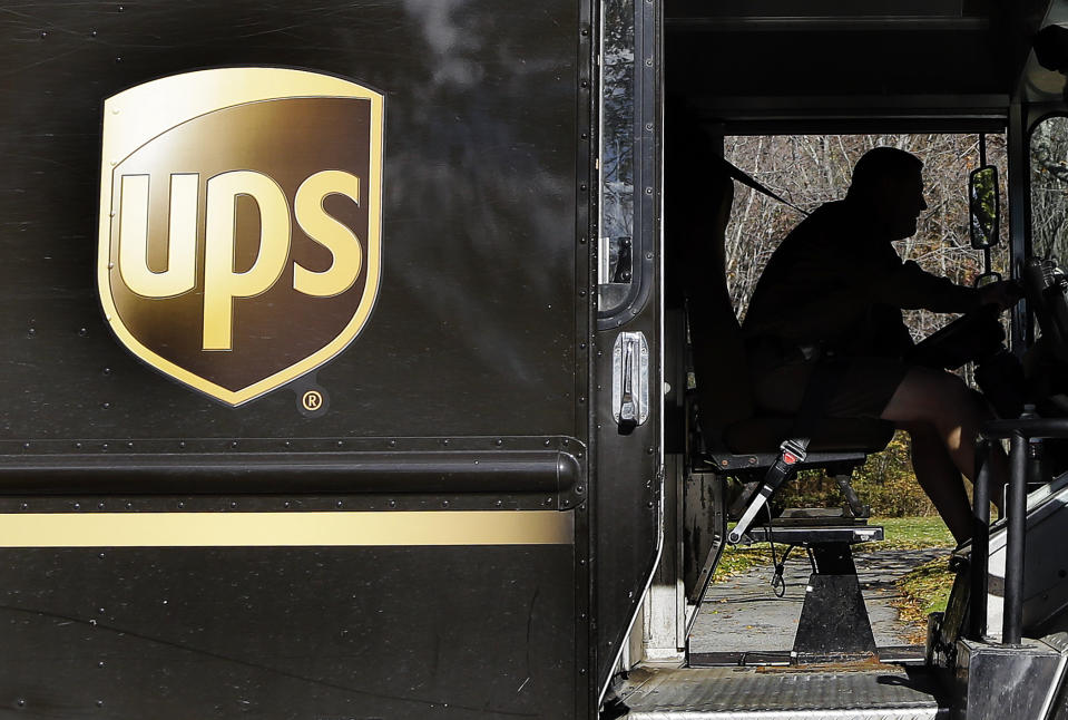 In this Monday, Oct. 22, 2012, photo, a UPS driver drives after a delivery in North Andover, Mass. In this Monday, Oct. 22, 2012, photo, a UPS driver makes a delivery in North Andover, Mass. UPS said Tuesday, Oct. 23, 2012, its third-quarter earnings sank on a huge penalty to withdraw from a pension plan. Without that charge, net income fell slightly but matched expectations on Wall Street. The world's largest package delivery company is also narrowing its earnings forecast for the full year. (AP Photo/Elise Amendola)