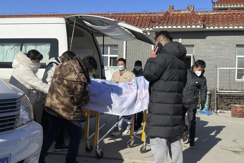 Workers unload a body from a vehicle for cremation at Gaobeidian Funeral Home in northern China's Hebei province, Thursday, Dec. 22, 2022. Nearly three years after it was first identified in China, the coronavirus is now spreading through the vast country. Experts predict difficult months ahead for its 1.4 billion people. (AP Photo, File)