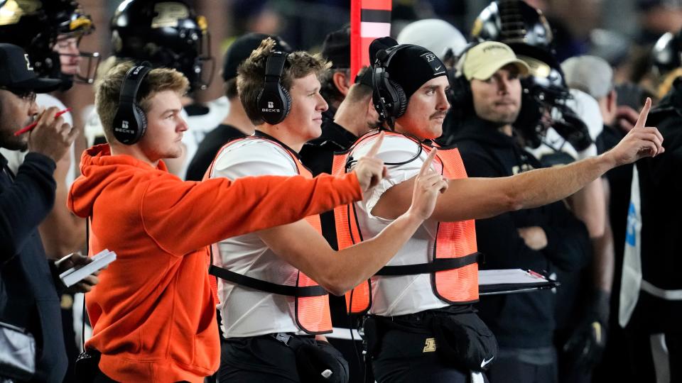 Purdue players signal offensive plays to the field from the sidelines against Michigan in the first half of an NCAA college football game in Ann Arbor, Mich., Saturday, Nov. 4, 2023.