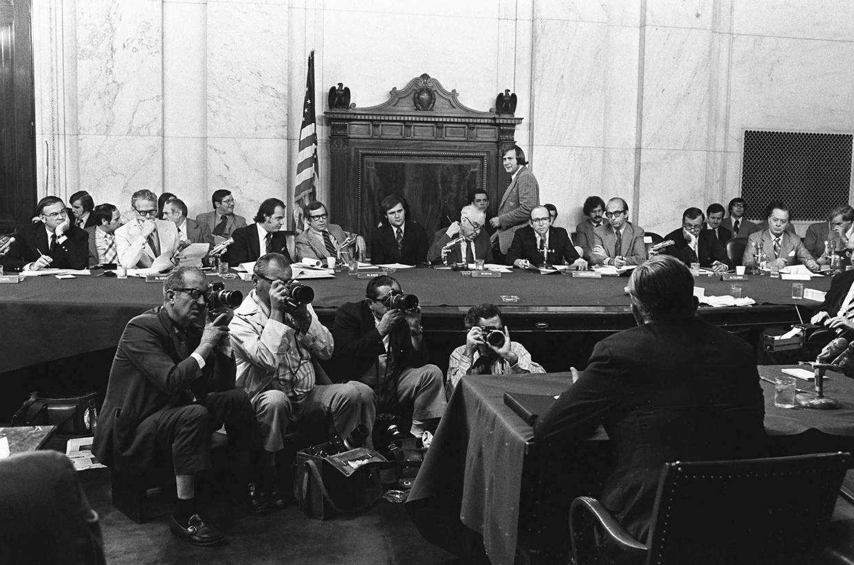 In this Aug. 3, 1973, file photo, the Senate Watergate Committee hearings continue on Capitol Hill in Washington, with from left, Sen. Lowell Weicker, Jr; Sen. Edward Gurney, Fred Thompson, Sen. Howard H. Baker; Rufus Edmisten, Sen. Sam Ervin; Sam Dash, and Sen. Joseph Montoya. Testifying is Lt. Gen. Vernon Walters. 