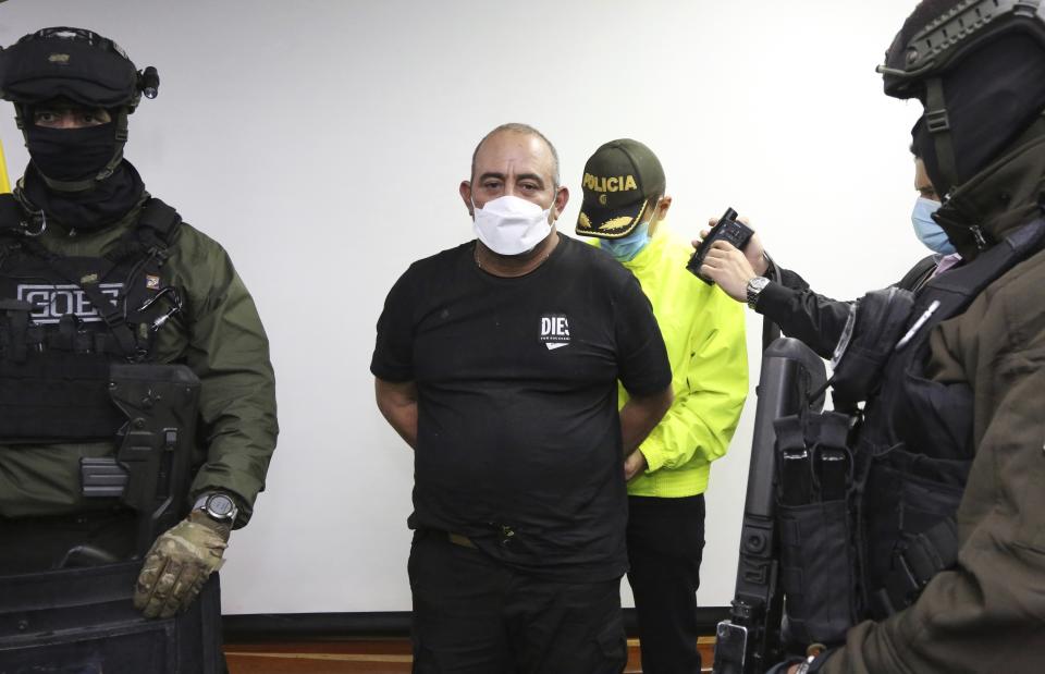 FILE - In this photo released by the Colombia Police Press Office, one of the country's most-wanted drug traffickers Dairo Antonio Usuga David, alias "Otoniel," is escorted in handcuffs in Bogota, Colombia, Oct. 23, 2021. Colombia started on Wednesday, May 4, 2022, the extradition of Usuga David to the United States. (Colombia Police Press Office via AP, File)