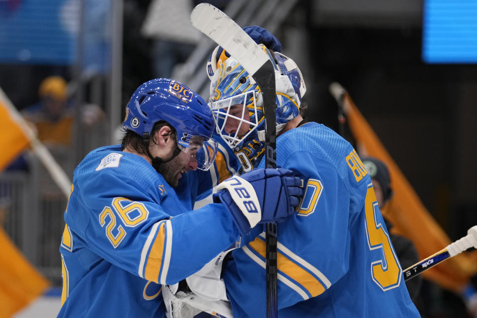 St. Louis Blues goaltender Jordan Binnington is congratulated by teammate Nathan Walker (26) following a 3-0 victory over the Washington Capitals in an NHL hockey game Saturday, Jan. 20, 2024, in St. Louis. (AP Photo/Jeff Roberson)