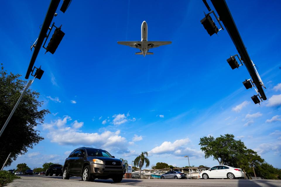 Planes approach to land at the Naples Airport as cars drive along Airport-Pulling Road on Thursday, March 14, 2024.