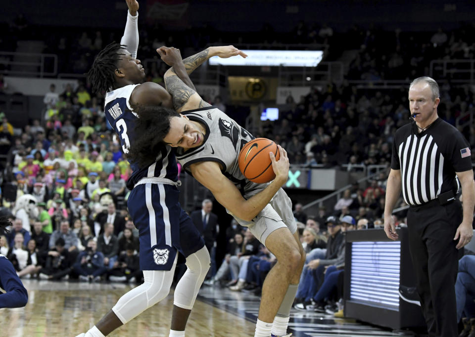 Providence's Devin Carter (22) is fouled on the sideline by Butler's Chuck Harris (3) during the first half of an NCAA college basketball game, Wednesday, Jan. 25, 2023, in Providence, R.I. (AP Photo/Mark Stockwell)