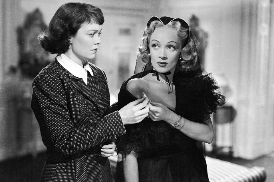 1950: Jane Wyman and Marlene Dietrich (1901 - 1992) share a cigarette in a scene from the murder mystery 'Stage Fright', directed by Alfred Hitchcock. (Photo via John Kobal Foundation/Getty Images)