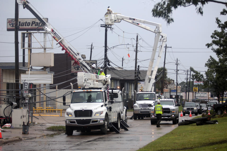 Utility crews work to restore electricity in Houston, Thursday, July 11, 2024. Officials say about 500,000 customers still won't have electricity into next week as wide outages from Hurricane Beryl persist. (AP Photo/Lekan Oyekanmi)