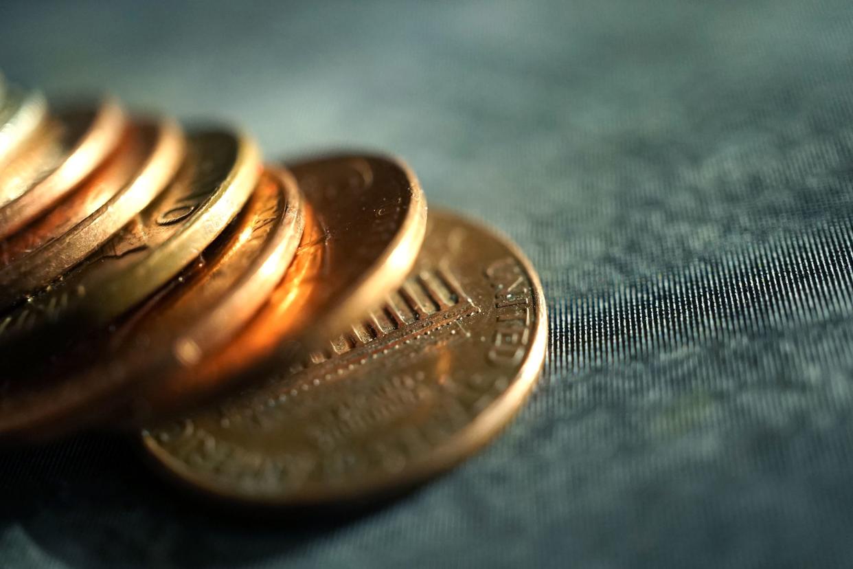 row of pennies on blue jean background