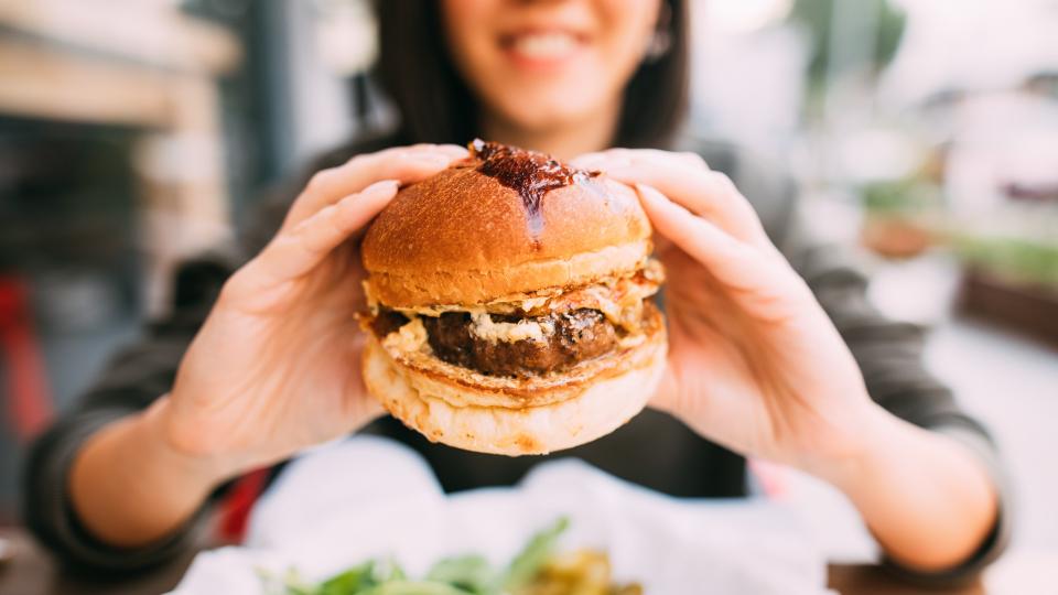 Woman eating beef burger.