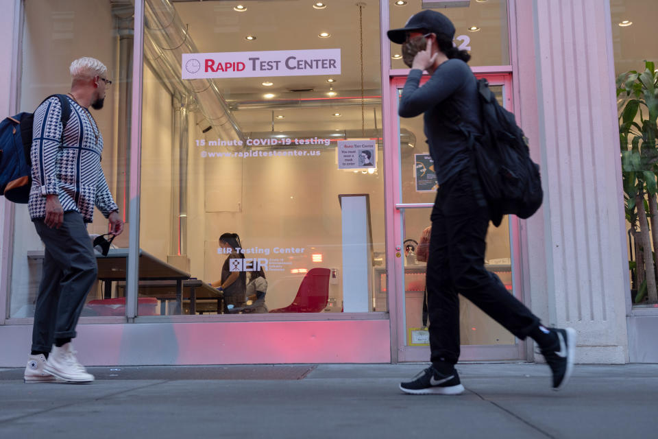 NEW YORK, NEW YORK - SEPTEMBER 29: People wearing masks walk past a Coronavirus Rapid Test Center as the city continues Phase 4 of re-opening following restrictions imposed to slow the spread of coronavirus on September 29, 2020 in New York City. The fourth phase allows outdoor arts and entertainment, sporting events without fans and media production. (Photo by Alexi Rosenfeld/Getty Images)