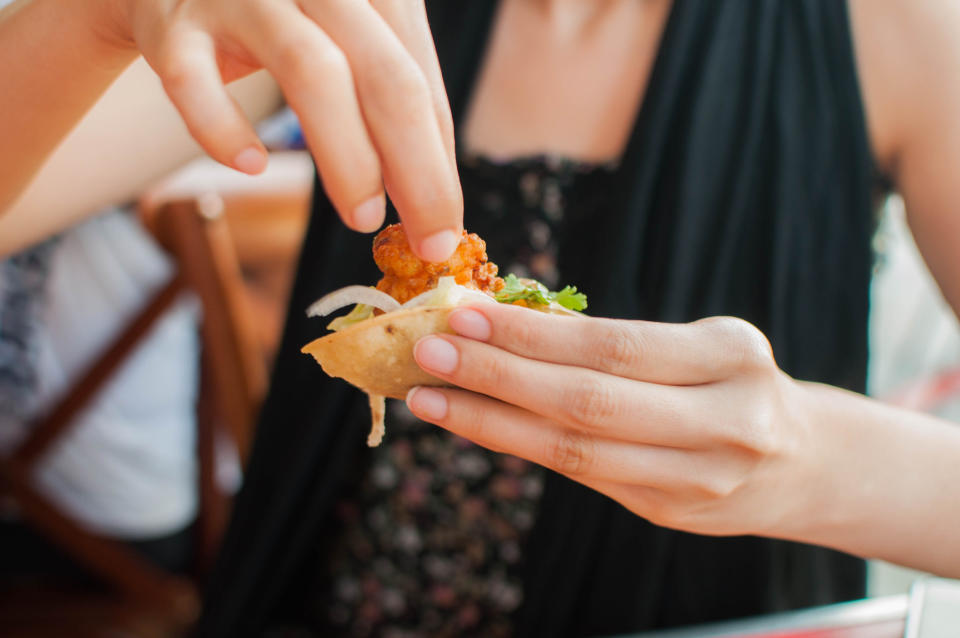 A woman eating a shrimp taco