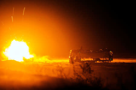 FILE PHOTO: A rocket fired by U.S. soldiers from Dragon Troop of the 3rd Cavalry Regiment explodes next to a destroyed bus at operating base Gamberi in the Laghman province of Afghanistan, December 31, 2014. REUTERS/Lucas Jackson