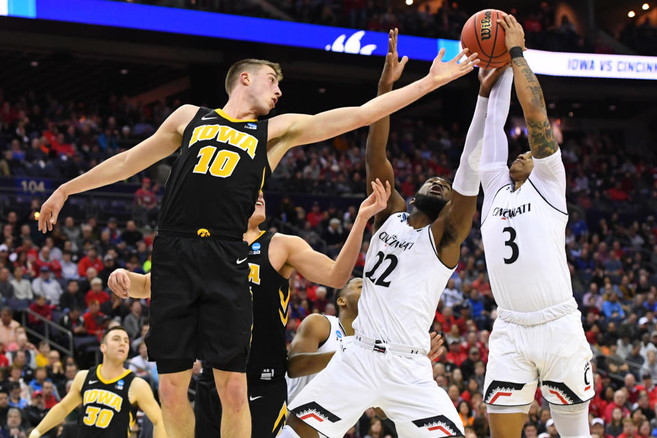 <p>Justin Jenifer #3 and Eliel Nsoseme #22 of the Cincinnati Bearcats fight for a rebound against Joe Wieskamp #10 of the Iowa Hawkeyes in the first round of the 2019 NCAA Men’s Basketball Tournament held at Nationwide Arena on March 22, 2019 in Columbus, Ohio. (Photo by Jamie Schwaberow/NCAA Photos via Getty Images) </p>