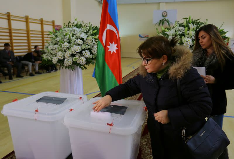 A woman casts her vote at a polling station during a snap parliamentary election in Baku