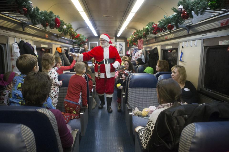 Santa Claus gives a child a high-five as he leaves the Polar Express on Saturday, Dec. 14, 2013. [File photo]