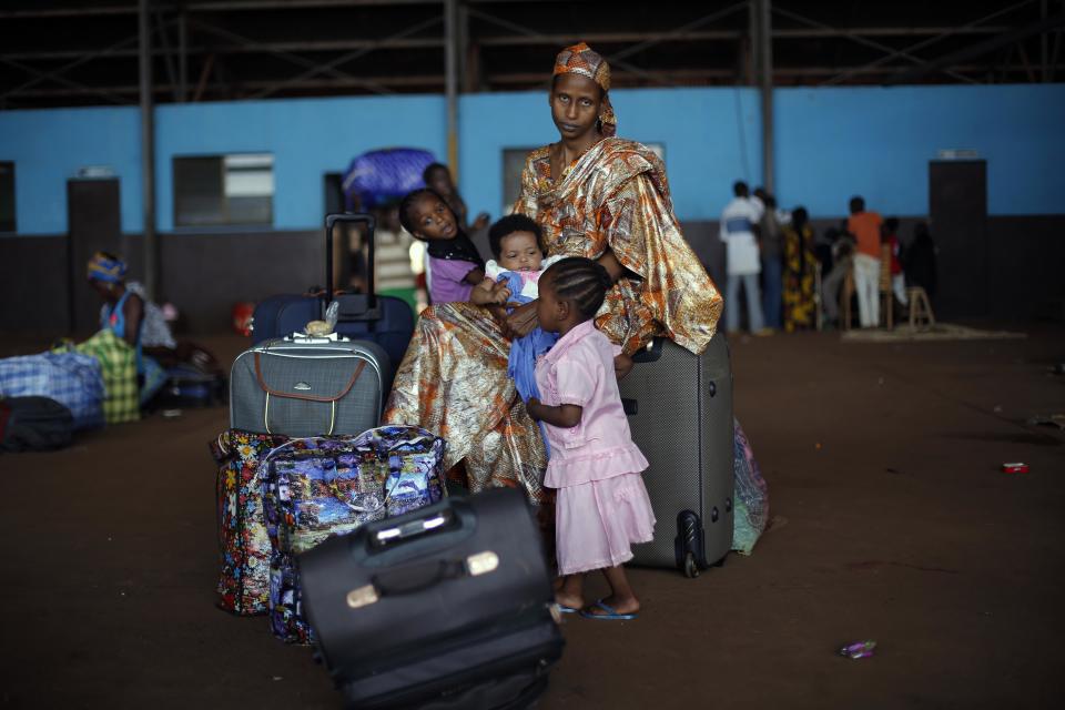 A Chadian family waits for transport to Chad in a hangar at Bangui's airport in Bangui, Central African Republic, Thursday Jan. 30, 2014. Over 350 Muslim refugees were evacuated by the UN's International Organization for Migration (IOM) fleeing sectarian violence between Muslim Seleka forces and Christian anti Balaka militias. (AP Photo/Jerome Delay)