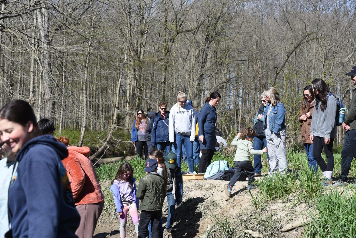 Community members watching Marysville High School students release salmon into the Belle River at Columbus County Park on April 26, 2024.