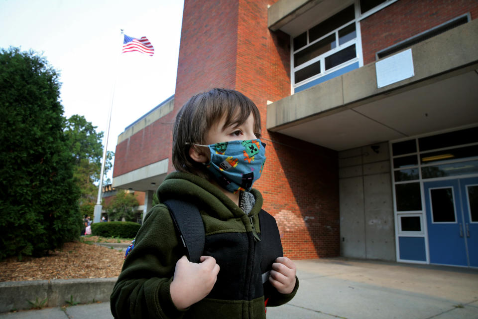 A boy arrives for the first day of school at the Lincoln-Hancock Community School in Quincy, MA on September 17, 2020. Thursday was the first day of in-person learning for half of the students (Cohort B) enrolled in the schools hybrid model. The school also offers a fully remote learning program. (Photo by Craig F. Walker/The Boston Globe via Getty Images)