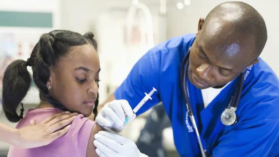 Una niña recibiendo una vacuna.