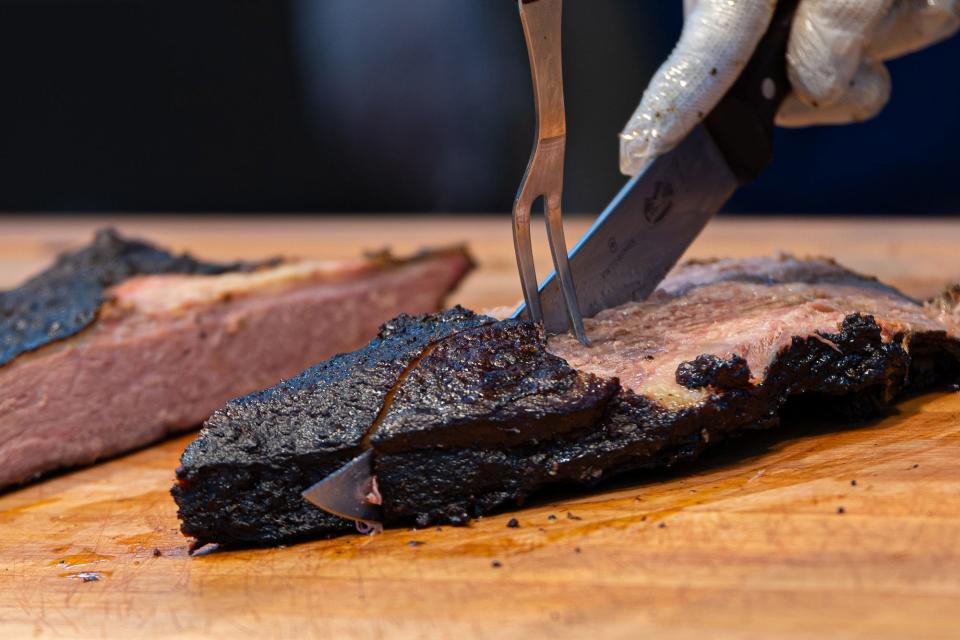 A Buc-ee's employee slices brisket at the Texas Round Up station, which serves brisket, sausage, turkey and pulled pork, at a Buc-ee's location.