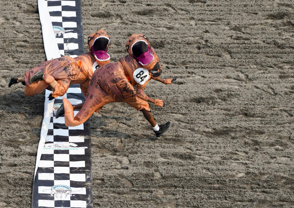 Dionte Gilbert (84) leaps across the finish line against Seth Hirschi, back, during the "T-Rex World Championship Races" at Emerald Downs, Sunday, Aug. 20, 2023, in Auburn, Wash. (AP Photo/Lindsey Wasson)