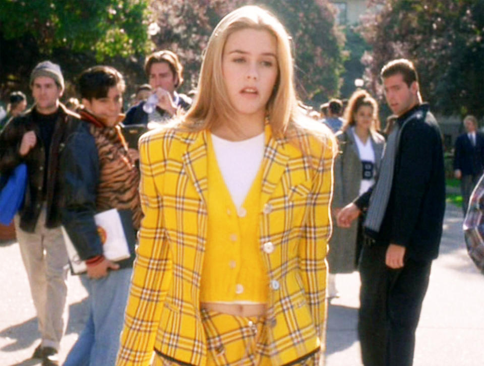 Alicia Silverstone as Cher walks around campus in a yellow co-ord outfit in "Clueless"