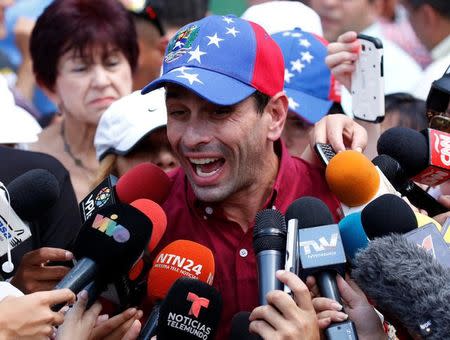 Venezuelan opposition leader and Governor of Miranda state Henrique Capriles (C) talks to the media at a polling station during an unofficial plebiscite against President Nicolas Maduro's government and his plan to rewrite the constitution, in Caracas, Venezuela July 16, 2017. REUTERS/Carlos Garcia Rawlins