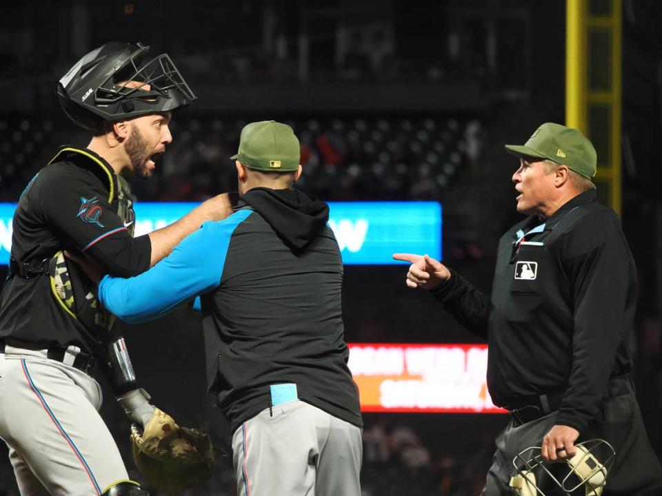 Miami Marlins catcher Jacob Stallings (58) is held back by manager Skip Schumaker (55) as he questions the call by home plate umpire Marvin Hudson (51) before being ejected during the eighth inning against the San Francisco Giants at Oracle Park on Friday, May 19, 2023.